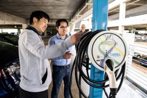 PowerFlex owner George Lee (left) works with NREL researchers as the startup’s adaptive charging network is installed in the laboratory’s parking garage.