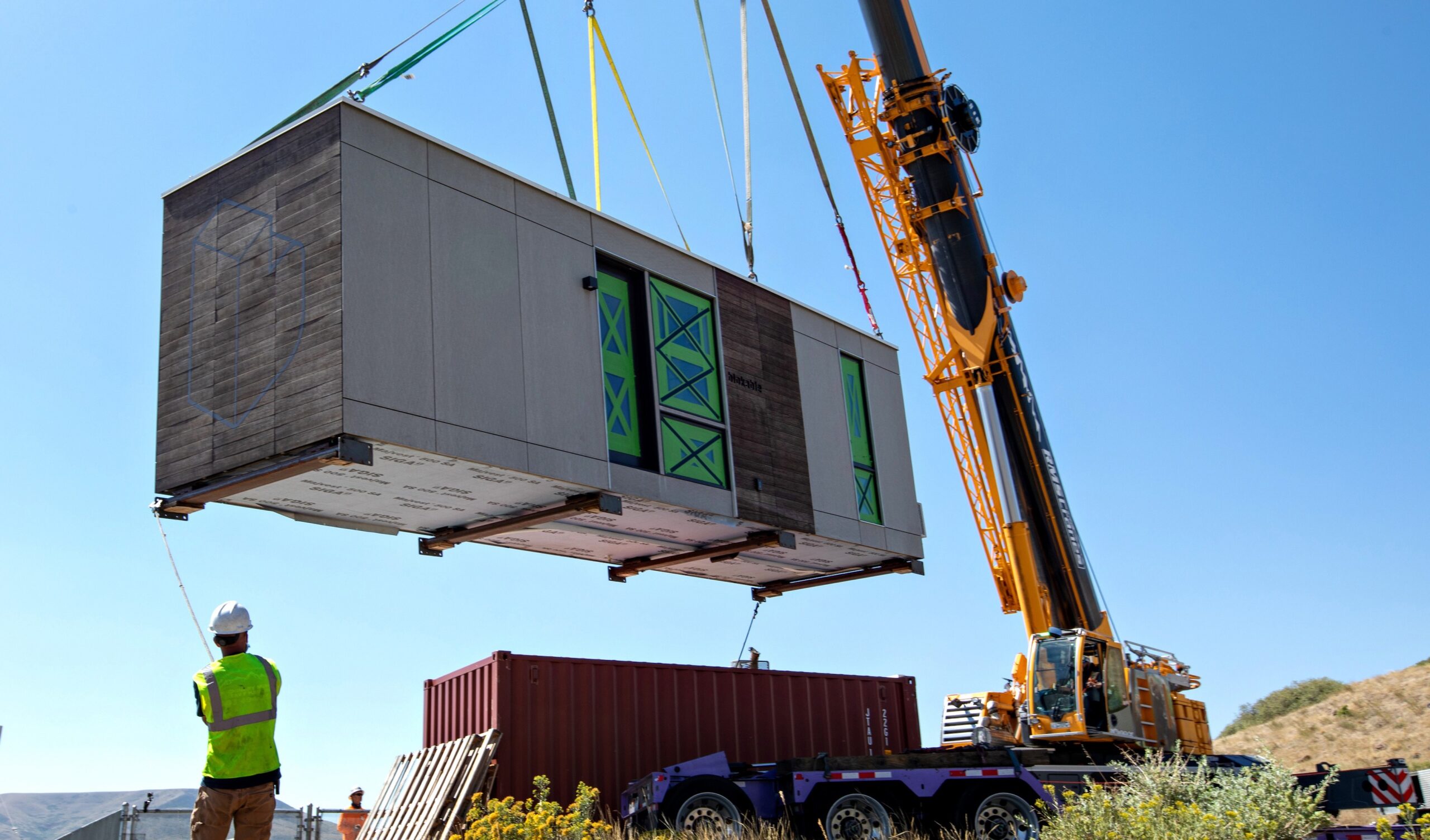 Crane postions a modular housing unit