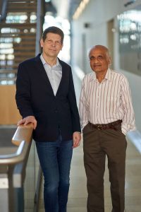 Two men pose for photo