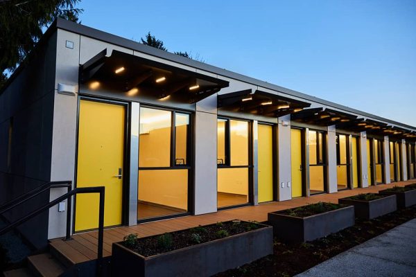 A row of modular homes lit up at dusk.