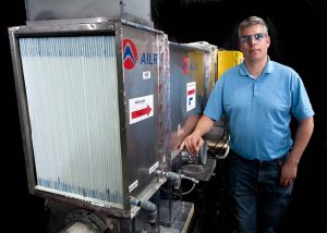 A man stands next to a large machine.