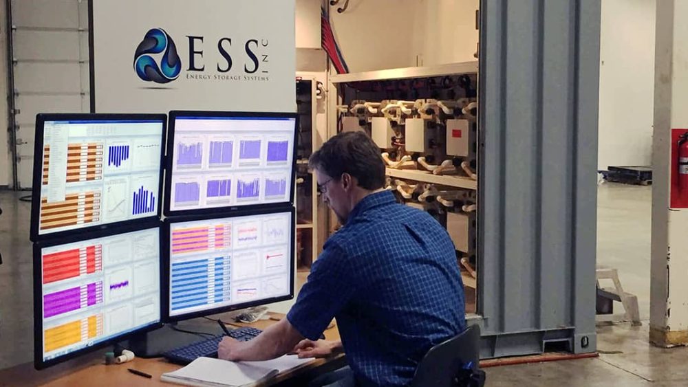 A man views multiple screens displaying colorful data graphs.