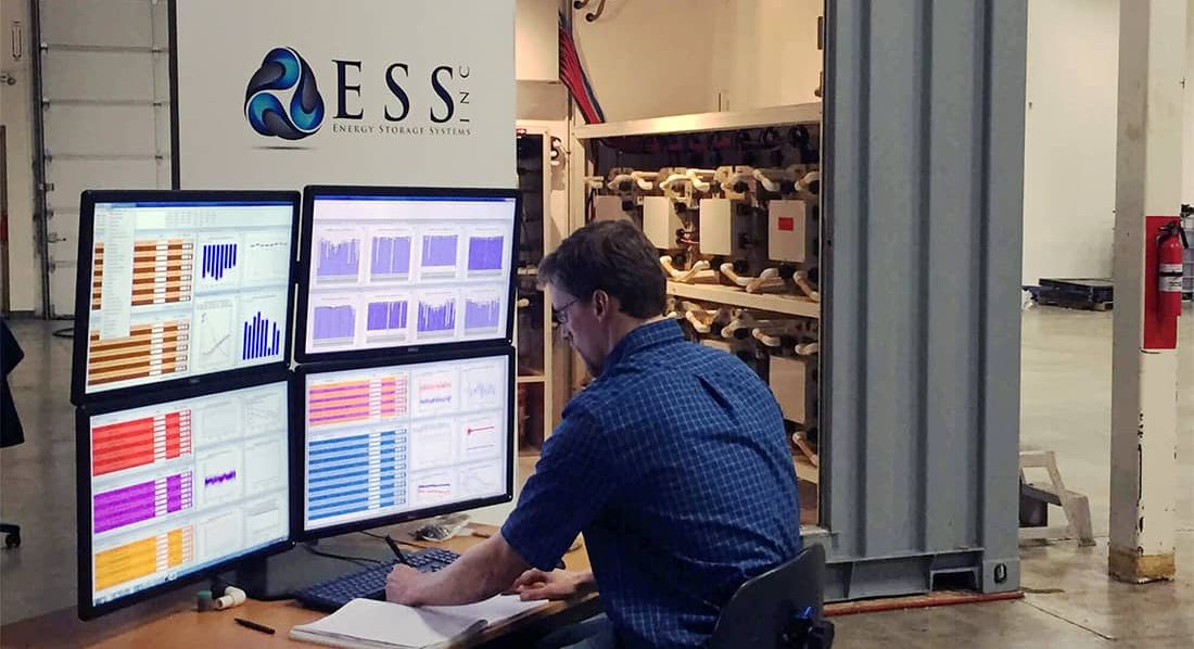 A man views multiple screens displaying colorful data graphs.