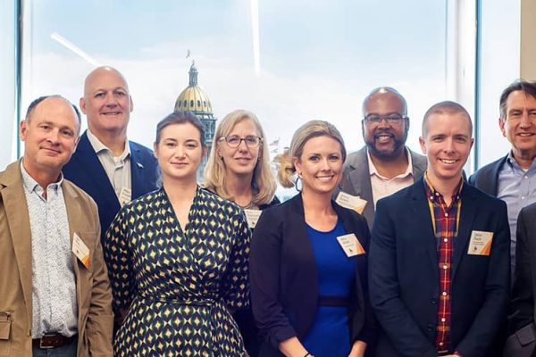 A group of 10 people pose and smile for the camera.