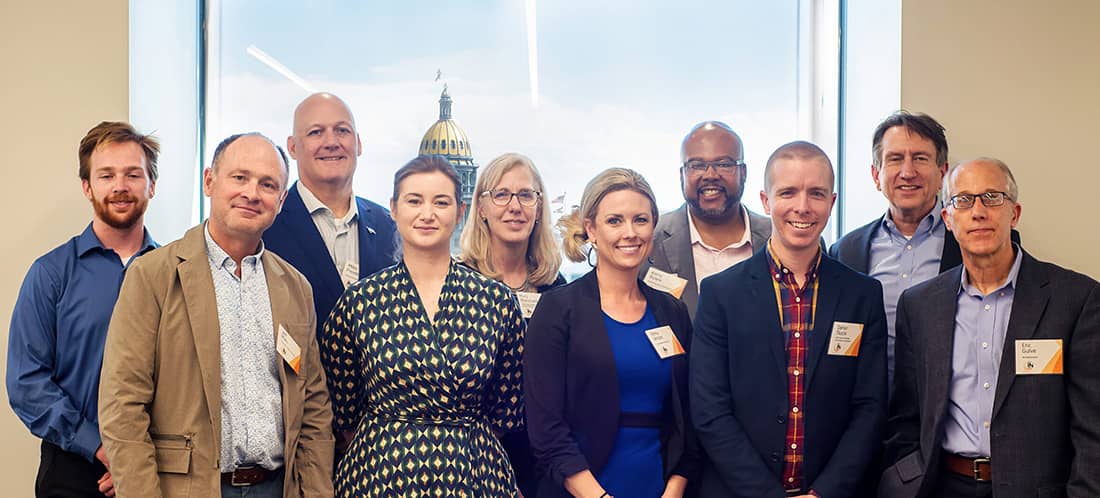 A group of 10 people pose and smile for the camera.