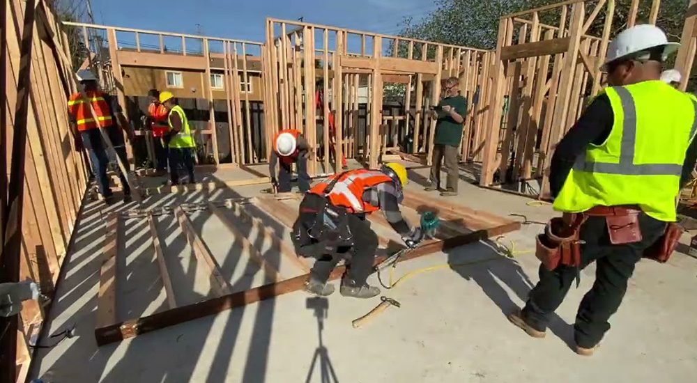 Workers build frame of home