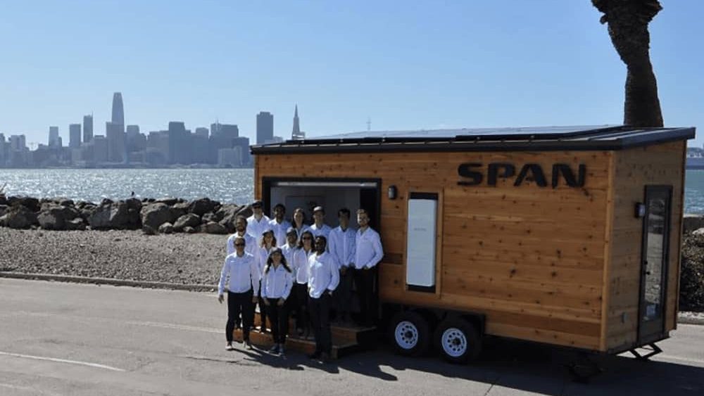 SPAN team poses for photo with city skyline in background