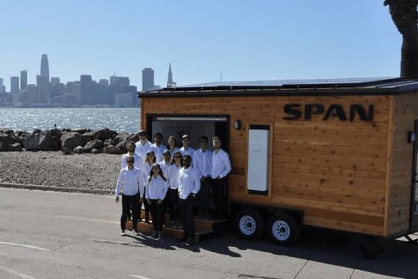 SPAN team poses for photo with city skyline in background