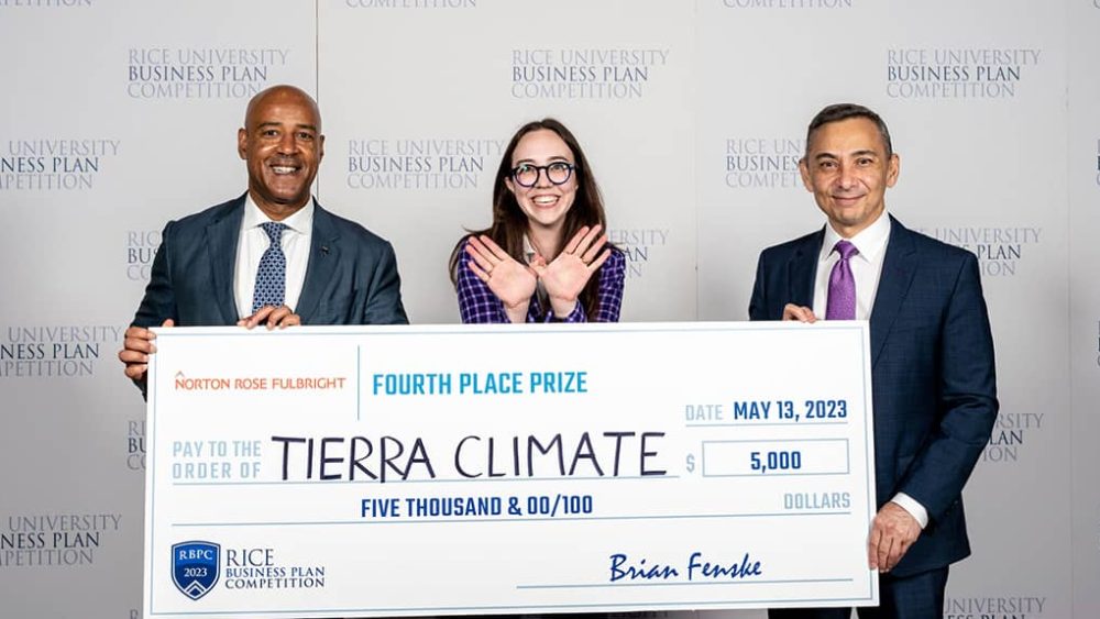 Three people holding a big check and smiling.