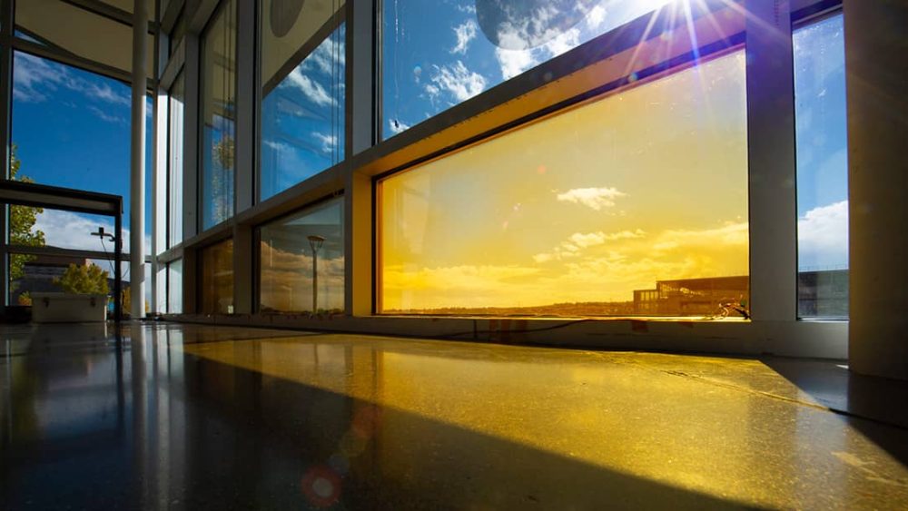 A yellow-colored window with blue sky behind it.