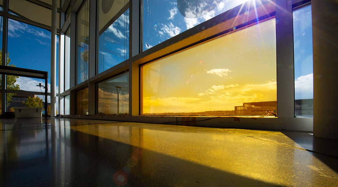 A yellow-colored window with blue sky behind it.