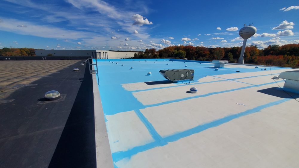 A wide view of a rooftop with a white and blue coating.