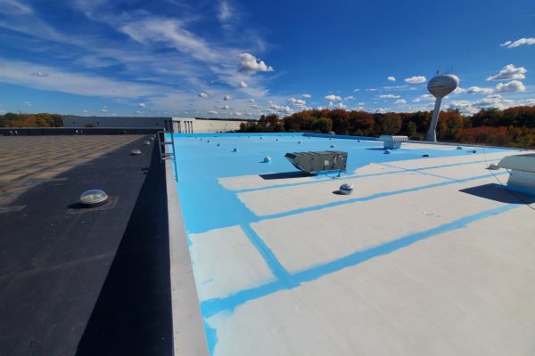 A wide view of a rooftop with a white and blue coating.